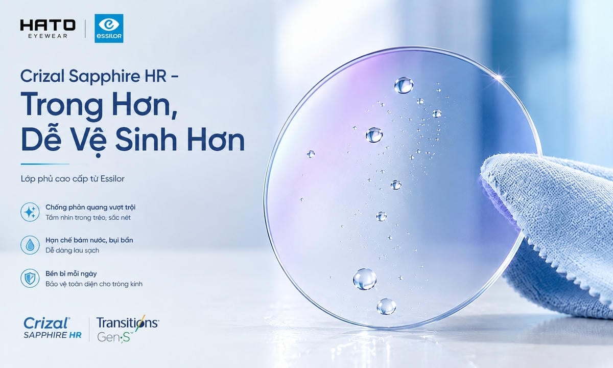 Ảnh minh họa blog cận cảnh tròng kính Essilor Transitions Gen S phủ Crizal Sapphire HR với bề mặt trong suốt, ánh phản quang xanh tím nhẹ, giọt nước bám trên kính và khăn microfiber lau nhẹ, thể hiện khả năng chống phản quang, dễ vệ sinh và hạn chế bám nước.
