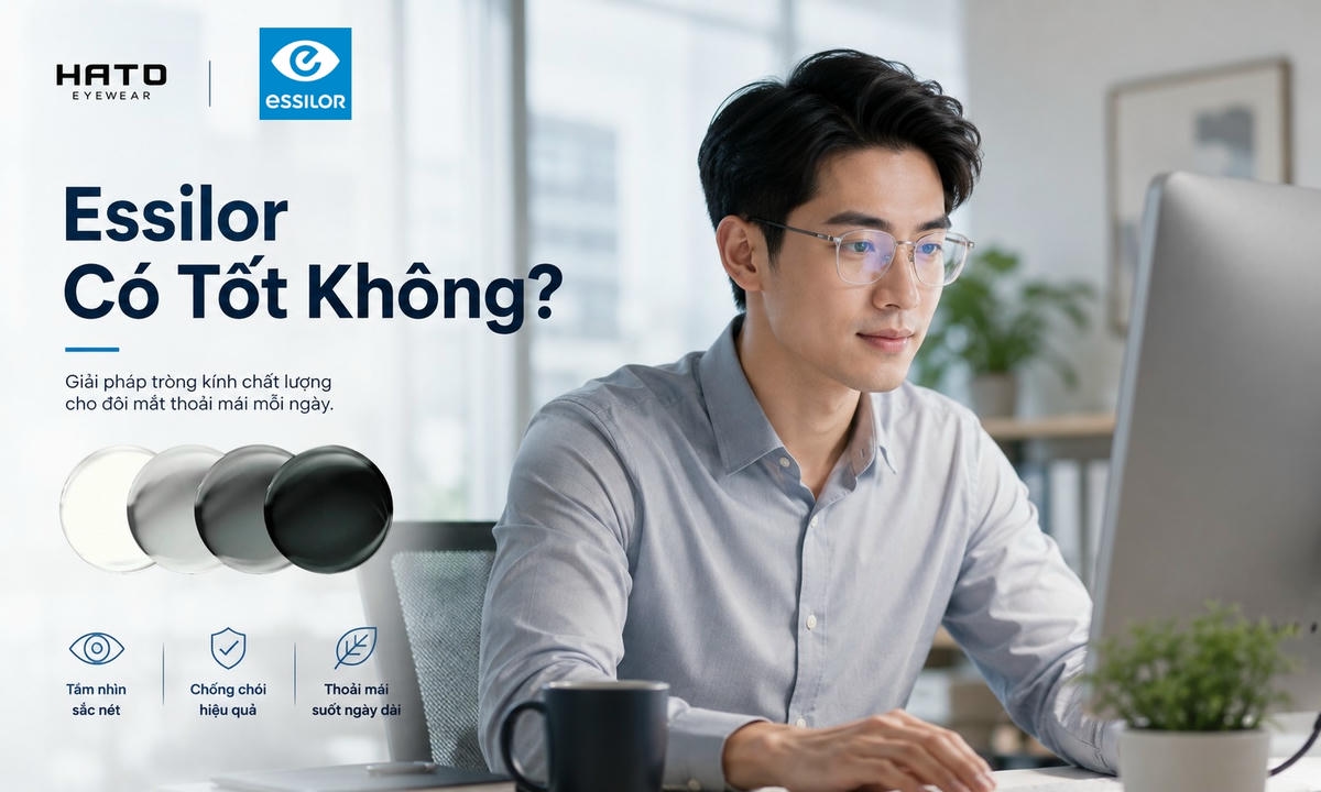 Người trẻ đeo kính làm việc trước máy tính trong văn phòng hiện đại, minh họa tròng kính Essilor cho tầm nhìn rõ nét và thoải mái.