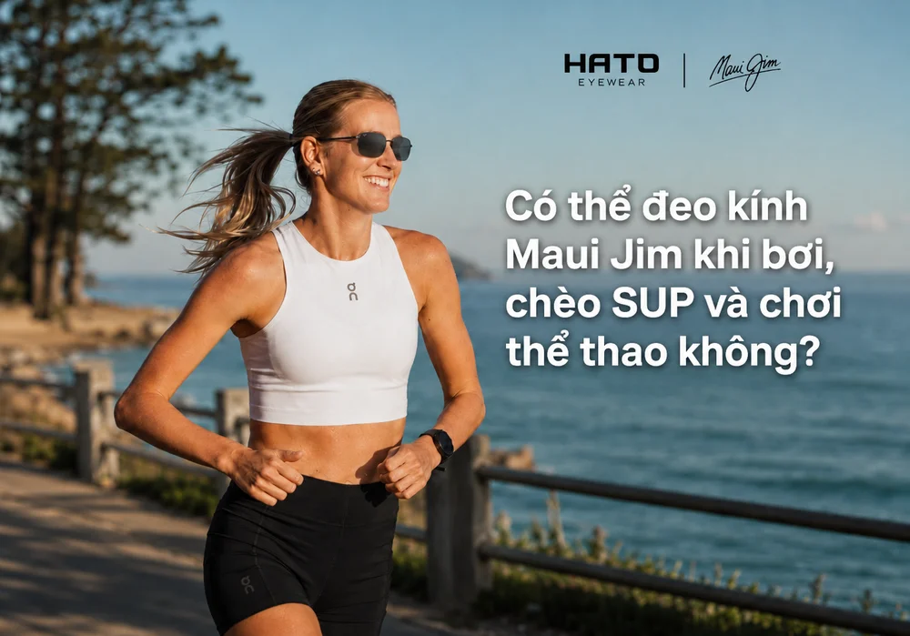 Nữ vận động viên đeo kính Maui Jim khi chạy bộ trên đường ven biển, minh họa khả năng sử dụng kính trong các hoạt động thể thao ngoài trời.