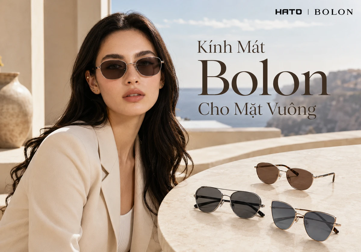 Người mẫu nữ mặt vuông nhẹ đeo kính mát Bolon dáng oval bo mềm, bên cạnh là các mẫu kính mát Bolon đặt trên bàn đá cao cấp tại Hato Eyewear.