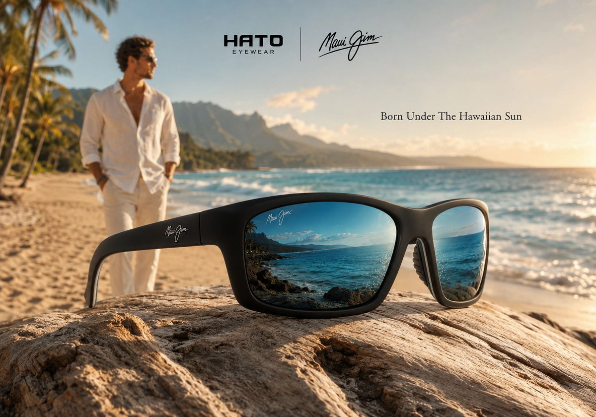 Kính mát Maui Jim tròng phản quang xanh đặt bên bờ biển Hawaii trong ánh nắng vàng, thể hiện phong cách premium và cảm hứng từ đại dương.