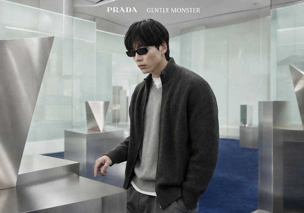 Kentaro Sakaguchi đeo kính đen PRADA GENTLE MONSTER trong không gian triển lãm nghệ thuật.