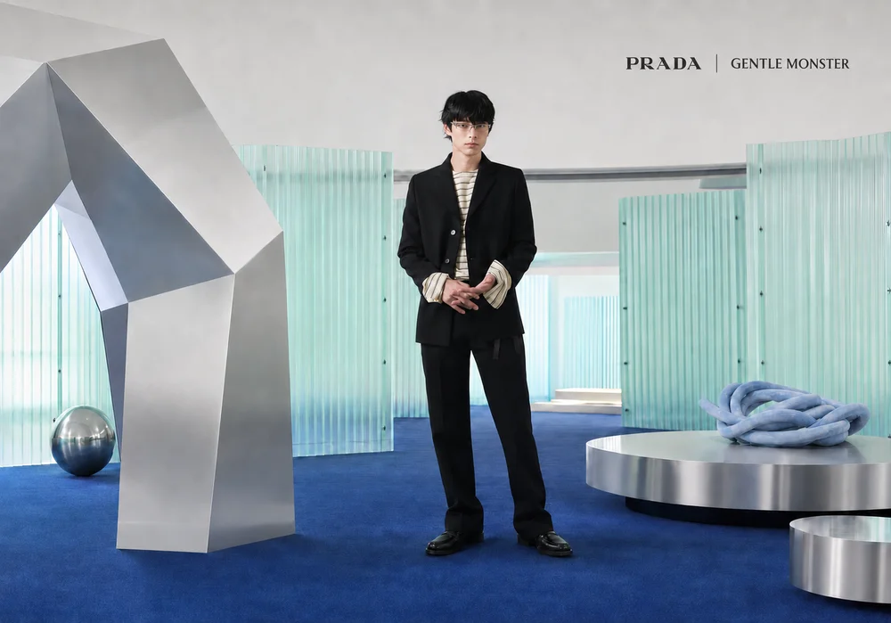 Kentaro Sakaguchi mặc vest đen và đeo kính PRADA GENTLE MONSTER trong không gian nghệ thuật.